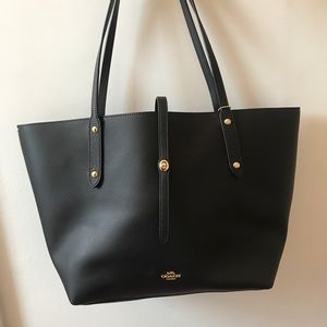 Black coach tote bag with red lining.